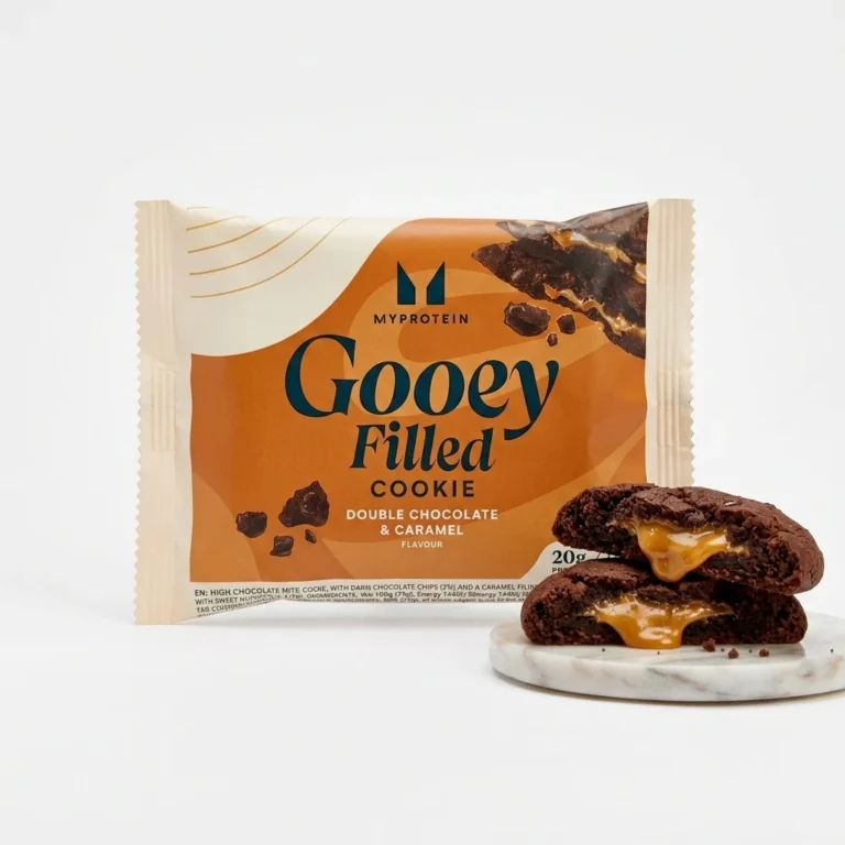 بسته‌بندی کوکی مغزدار Myprotein Gooey Filled Cookie با طعم دابل چاکلت و کارامل به‌همراه نمای برش‌خورده